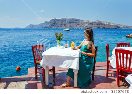 Young woman in a restaurant by the sea Young woman in a restaurant by the sea 55507678