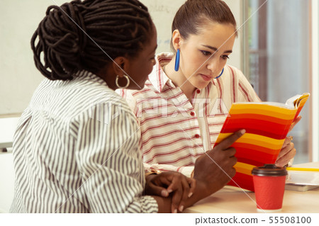 Concentrated young female reading task in book Concentrated young female reading task in book 55508100