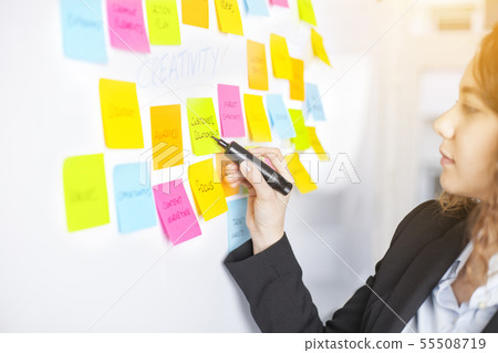Creative woman use post-it notes to share idea 55508719
