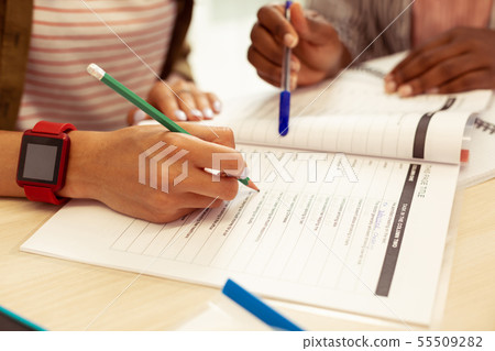 Two students completing task in their copybook Two students completing task in their copybook 55509282
