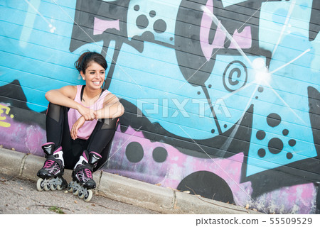Young brunette woman on rollerskate smiling 55509529