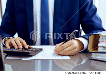 Bookkeeper or financial inspector hands making report, calculating or checking balance. Internal 55510040