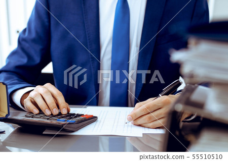 Bookkeeper or financial inspector hands making report, calculating or checking balance. Internal Bookkeeper or financial inspector hands making report, calculating or checking balance. Internal 55510510