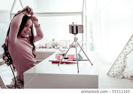 Joyful happy girl doing a beautiful hairstyle 55511103