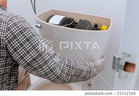 Man worker repairing with toilet tank in bathroom, 55512104