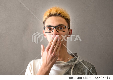 Boy putting his hand in front of his mouth Boy putting his hand in front of his mouth 55513815
