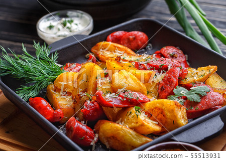 Potato baked with sausages and decorated with herbs. 55513931