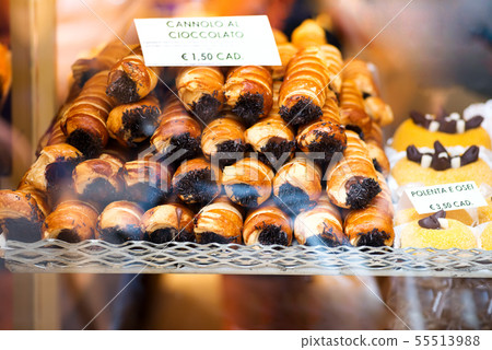 Closeup of cannoli stuffed with cream chocolate whipped filling dessert on tray window display in 55513988