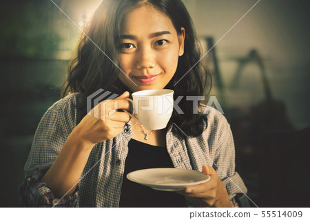asian younger woman  drinking hot coffee in white 55514009