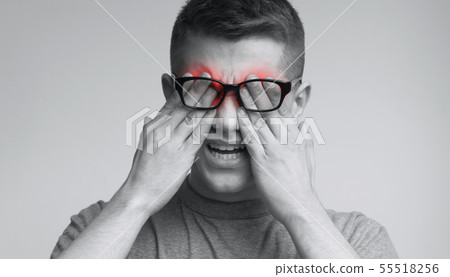 Young caucasian man in glasses rubbing his eyes Young caucasian man in glasses rubbing his eyes 55518256