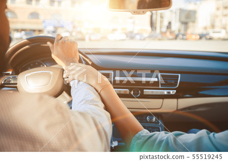 Loving couple traveling by car and holding hands Loving couple traveling by car and holding hands 55519245