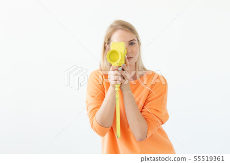 Photographer, hobby and leisure concept - Young blond woman with retro camera on white background 55519361