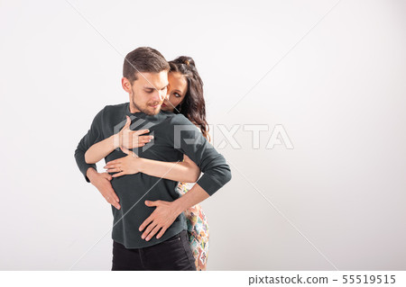Skillful dancers performing in the white background with copy space. Sensual couple performing an Skillful dancers performing in the white background with copy space. Sensual couple performing an 55519515