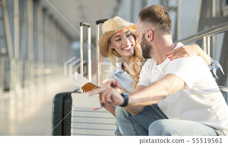 Loving couple in airport using travel app on smartphone 55519561