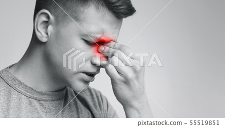 Upset man holding his inflamed nose, black and white photo 55519851