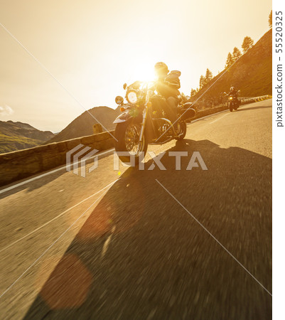 Motorcycle driver riding in Alpine highway, Nockalmstrasse, Austria, Europe. Motorcycle driver riding in Alpine highway, Nockalmstrasse, Austria, Europe. 55520325