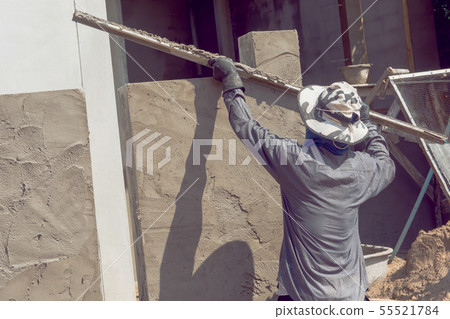 Construction workers plastering building wall 55521784