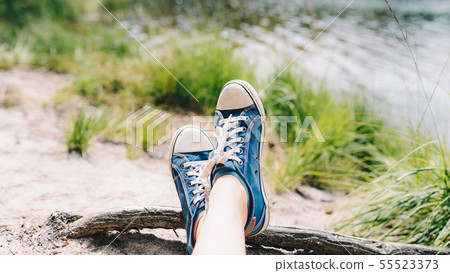 Foot and legs seen from above on a lake beach 55523373