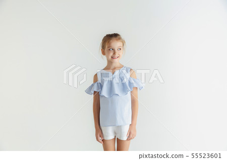 Little smiling girl posing in casual clothes on white studio background Little smiling girl posing in casual clothes on white studio background 55523601