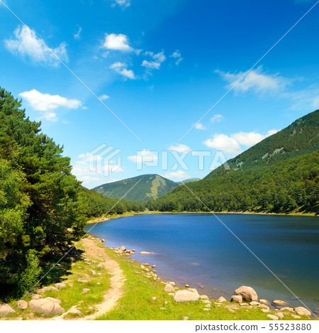 Picturesque lake, mountains and blue sky. Picturesque lake, mountains and blue sky. 55523880