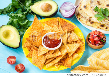 Mexican tortilla chips with paprika and tomato sauce Mexican tortilla chips with paprika and tomato sauce 55523894