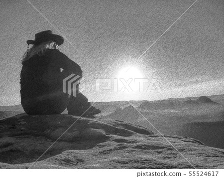 Girl sitting on a stone beside peaks under the Girl sitting on a stone beside peaks under the 55524617