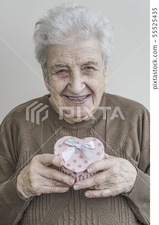 senior woman holding heart shaped gift senior woman holding heart shaped gift 55525435