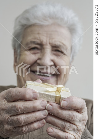 senior woman holding gift on her hands senior woman holding gift on her hands 55525573