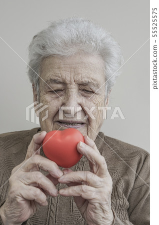 senior woman holding a red heart 55525575