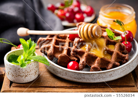 Tasty Belgian waffles with honey and berries Tasty Belgian waffles with honey and berries 55526034