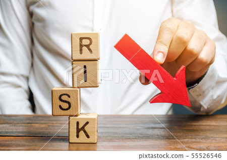 Wooden blocks with the word Risk and a down arrow. Wooden blocks with the word Risk and a down arrow. 55526546