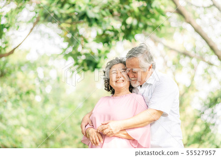 Happy senior couple in love embracing in park 55527957