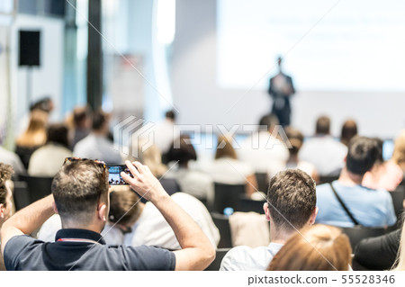 Male business speaker giving a talk at business conference event. Rear view of unrecognized Male business speaker giving a talk at business conference event. Rear view of unrecognized 55528346