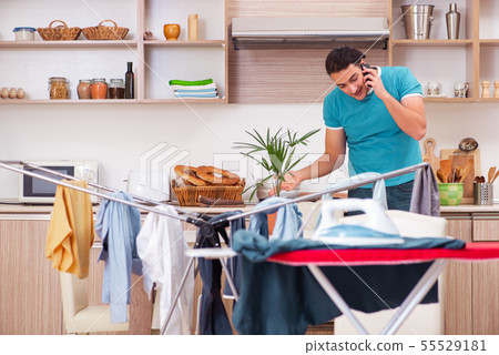 Young man husband doing clothing ironing at home 55529181