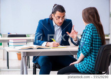 Young handsome teacher and female student in the classroom 55529290