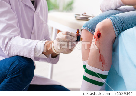Leg injured young woman visiting male doctor 55529344