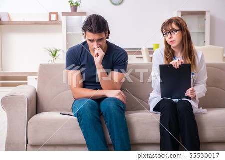 Young male patient discussing with female psychologist personal 55530017