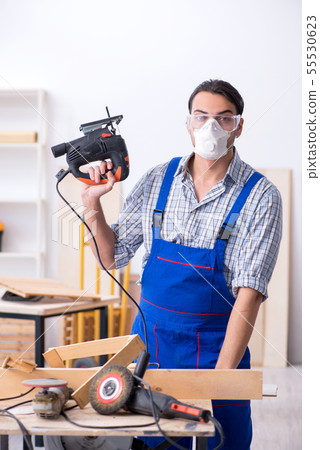 Young male carpenter working indoors 55530623