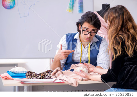 Young male tailor talking to female customer Young male tailor talking to female customer 55530855