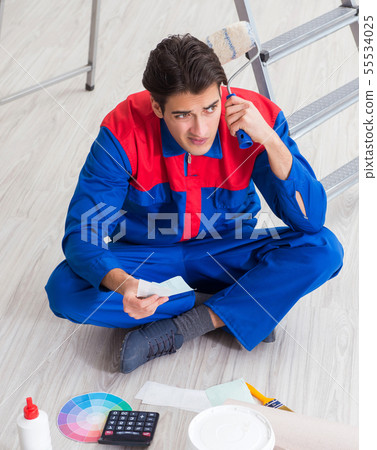 Young painter trying to match colours for painting job 55534025