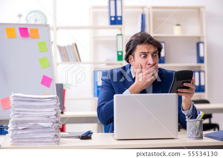 Young male employee unhappy with excessive work 55534130