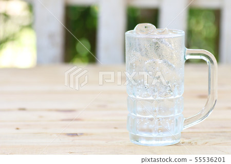 Glass of water with ice on wooden table 55536201