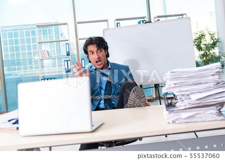 Chained male employee unhappy with excessive work Chained male employee unhappy with excessive work 55537060