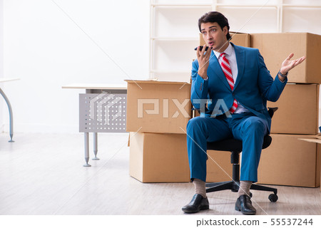 Young handsome businessman moving to new workplace Young handsome businessman moving to new workplace 55537244