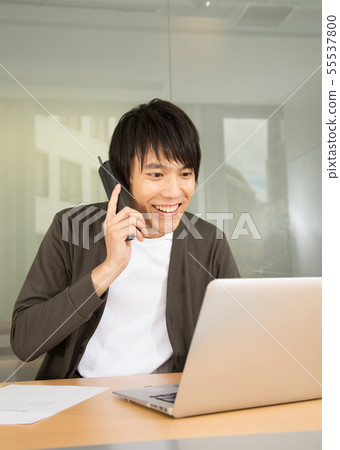 A man who supports the phone with a smile 55537800