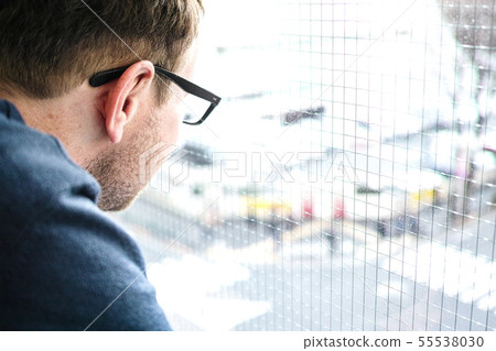 a man looking at the traffic out of the window 55538030