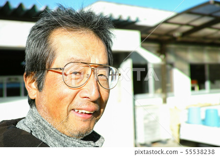 An old farmer smiling at the camera before heading off to work 55538238