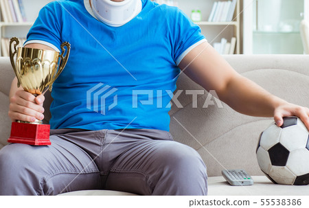 Man with neck injury watching football soccer at home Man with neck injury watching football soccer at home 55538386