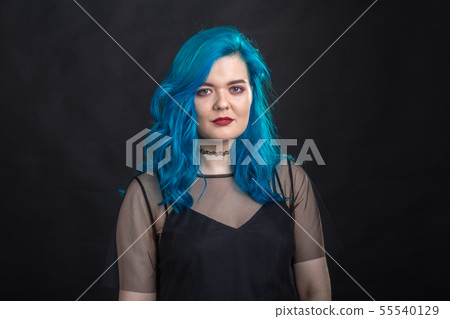 Style and fashion concept - Young and attractive woman with blue hair posing over black background Style and fashion concept - Young and attractive woman with blue hair posing over black background 55540129