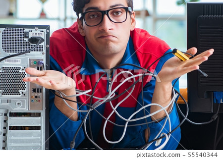 Computer repairman working on repairing computer in IT workshop Computer repairman working on repairing computer in IT workshop 55540344